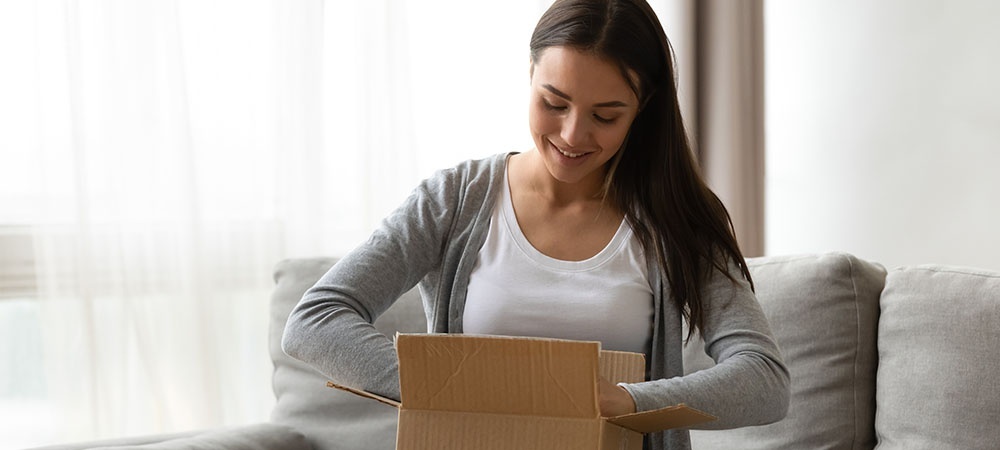 woman opening a box with her mail-order marijuana products