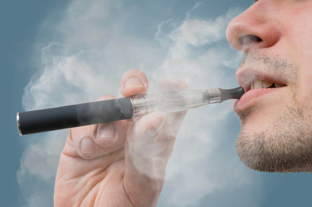 Closeup of a man exhaling weed pen vapour